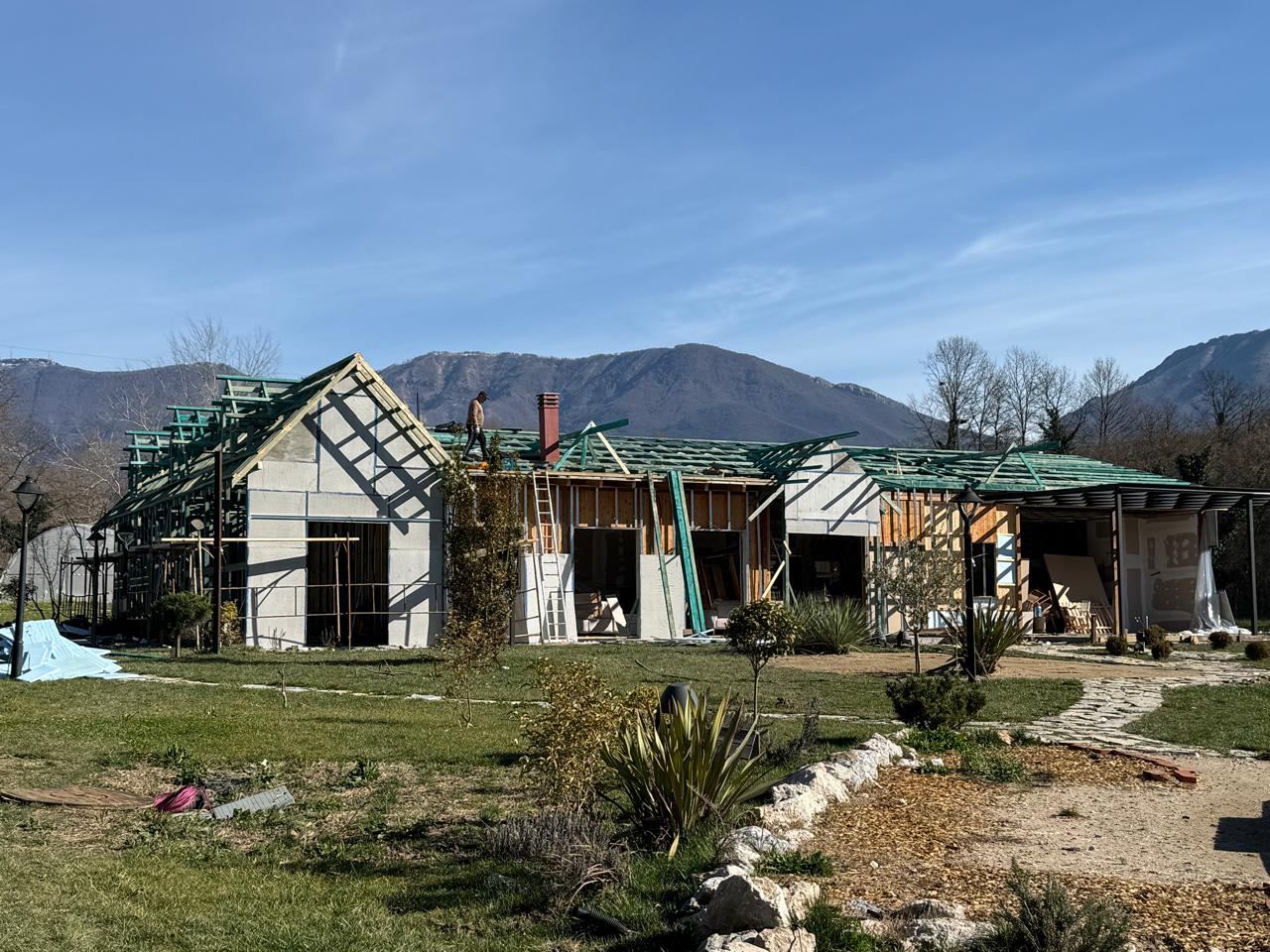 Ferma VIP under construction, exposed structural framework within a rural landscape