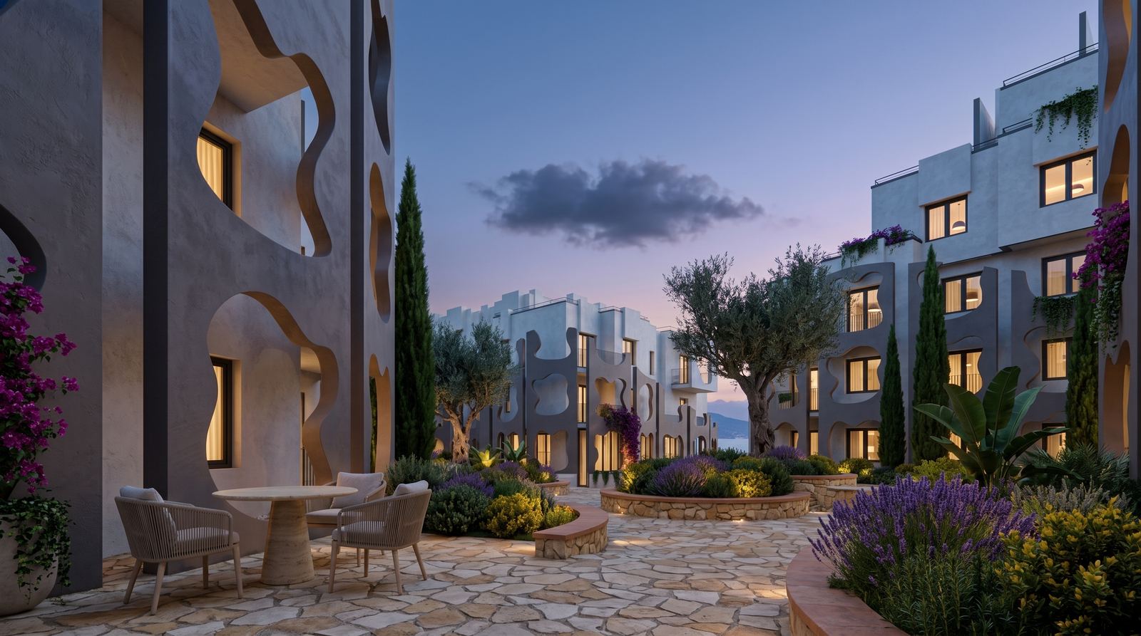 An intimate outdoor dining terrace with flagstone paving, surrounded by raised planters with lavender, olive trees, and residential buildings with sculpted facade cutouts at twilight.
