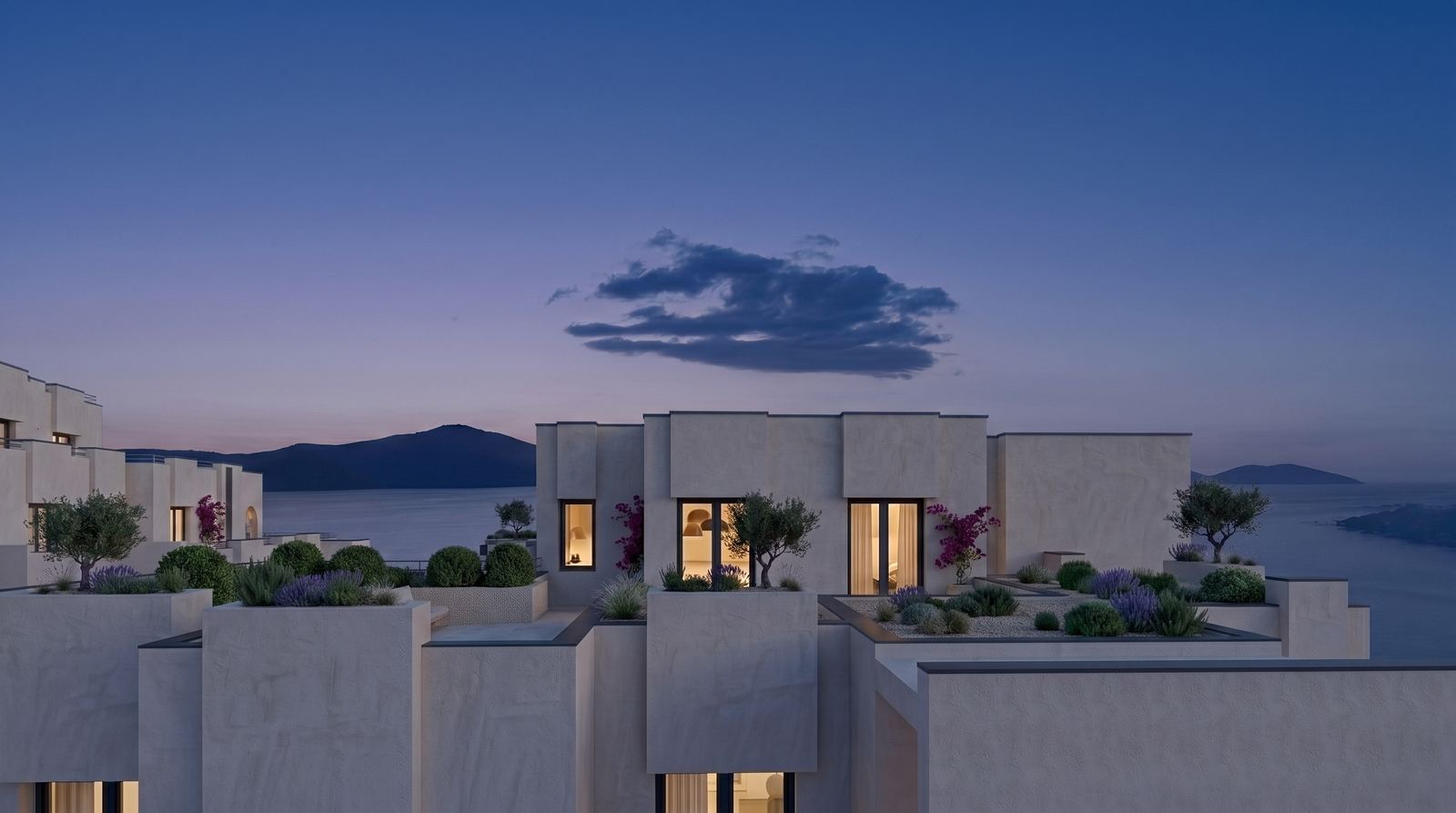 Rooftop terraces with planted gardens overlooking the sea and Karaburun silhouette at dusk.