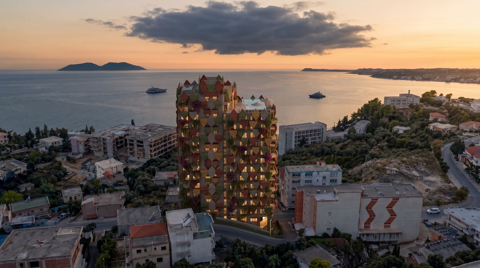 The Leaves residential tower illuminated against the dusk horizon of Vlorë bay.